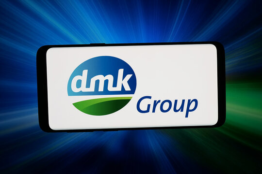 Stuttgart, Germany - 07-08-2026: In this photo illustration, the logo of dairy company DMK Deutsches Milchkontor GmbH is displayed on a smartphone in front of abstract background on computer screen.