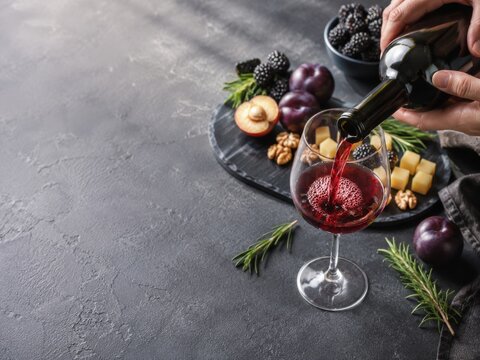 Disfrutar de una cena con vino tinto y frutas en una mesa de cocina