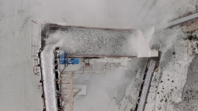 Industrial stone crushing machine operating in a marble quarry, crush rocks and transporting them on conveyor belts