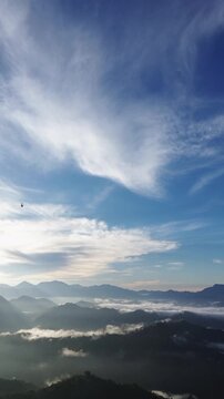 Aerial View of Misty Mountain Range Under Blue Sky