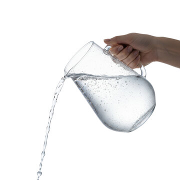 Elegant hand with clear manicure pours sparkling water from cold, condensed crystal pitcher in high-key studio, strong backlighting, sharp focus. Concept for beverage advertising