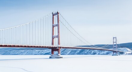 Fototapeta premium A grand suspension bridge spans across a frozen river during a cold winter day, with snow covering the steel cables and distant horizons, majestic, overcast, serene