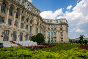 Fototapeta premium Side facade and entrance steps of the Palace of the Parliament with green garden in Bucharest Romania