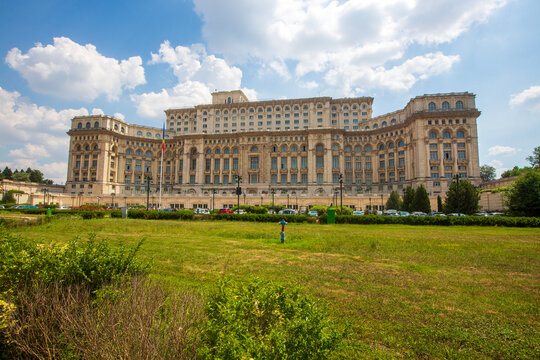 Front facade of the Palace of the Parliament with a wide green lawn in Bucharest Romania