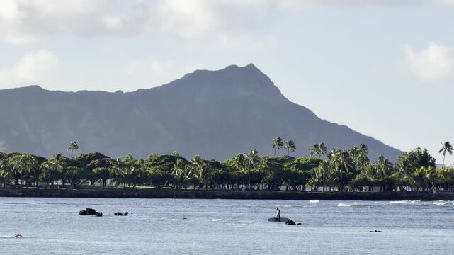 In the distance are Diamond Head Crater (a tuff cone) and Magic Island (is a small man-made peninsula) . Kewalo Basin Park, City of Honolulu, Oahu, Hawaii. 