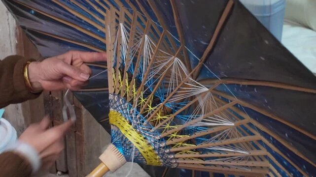 Craftsmen are making oil paper umbrellas
