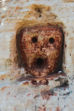 Engraving depicting a faces. Rock drawings and scratch-carvings, pictographs and abstract signs made with red ochre on the limestone cliffs along the "Cammino del Salento" hiking trail. Puglia Region,