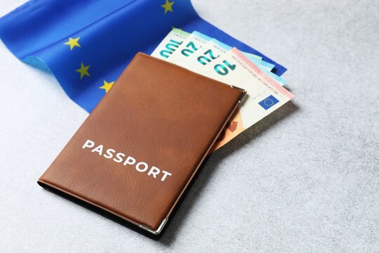 Passport in brown cover with euro banknotes and European Union flag