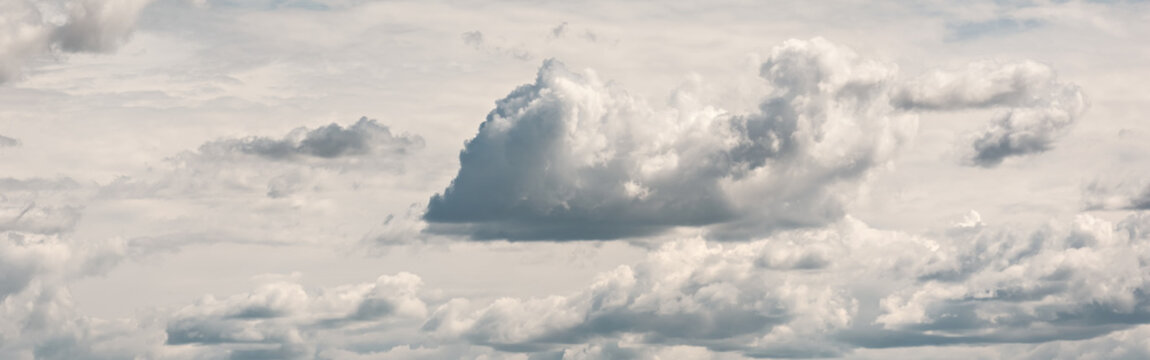 Cumulus clouds floating against the background of the upper cloud layer, panoramic banner