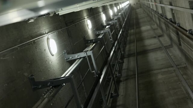 Elevator shaft guide rails and maintenance lighting with upward view
