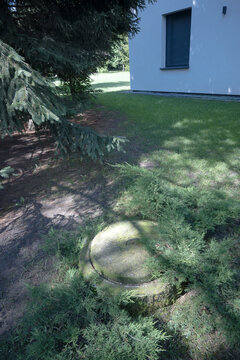 Concrete septic tank in front of a single-family house.
