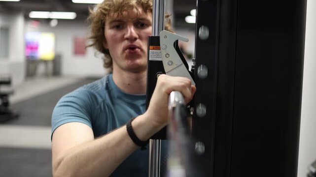 Young athlete pushes through intense cable workout with determined focus building upper body strength and endurance during challenging gym training session indoors