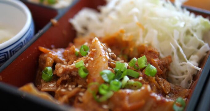 Close up of delicious Korean stir fried pork with kimchi in bento box