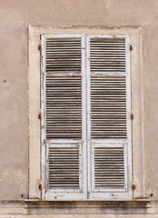 Fototapeta premium White painted timber window shutters with the paint in poor condition