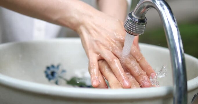 Close up of washing hands with clean water under tap faucet