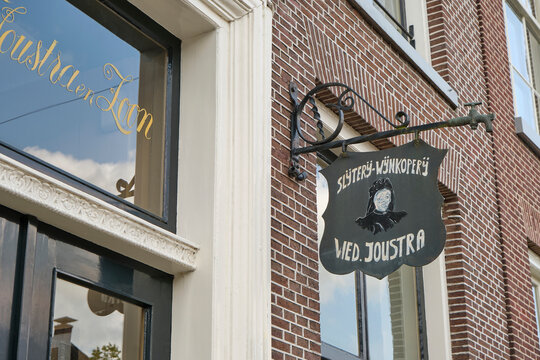 Sign with the Weduwe Joustra logo. Weduwe Joustra is a Frisian spirits brand called Beerenburg uit Sneek and founded in 1864.	