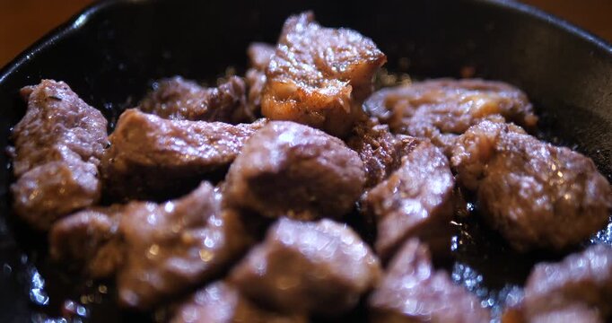 Close up of juicy diced beef steak cubes on hot pan