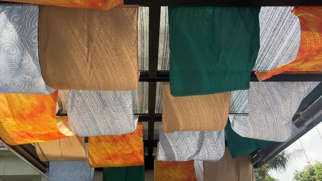 Colorful decorative fabric hanging from a grid ceiling structure