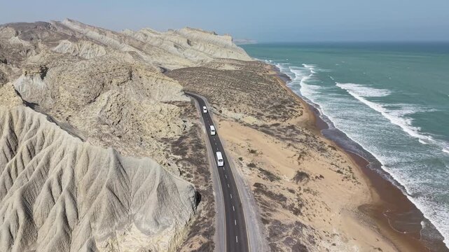 Aerial Drone View of Makran Coastal Highway Balochistan Along Sandy Beach and Ocean Waves in Desert Landscape