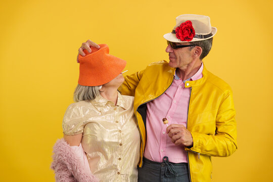 Senior couple enjoying vibrant healthy positive maturity against yellow