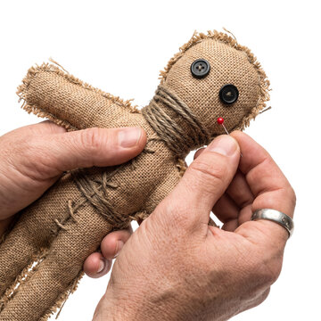 Voodoo Doll Cursed by Pin Held in Hands
