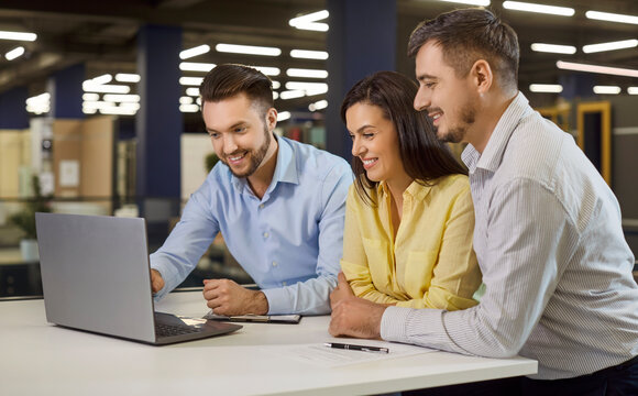 Couple clients consult salesman in hardware store using laptop before purchase for home renovation, navigating options in a retail space dedicated to informed decisions and improvement solutions.