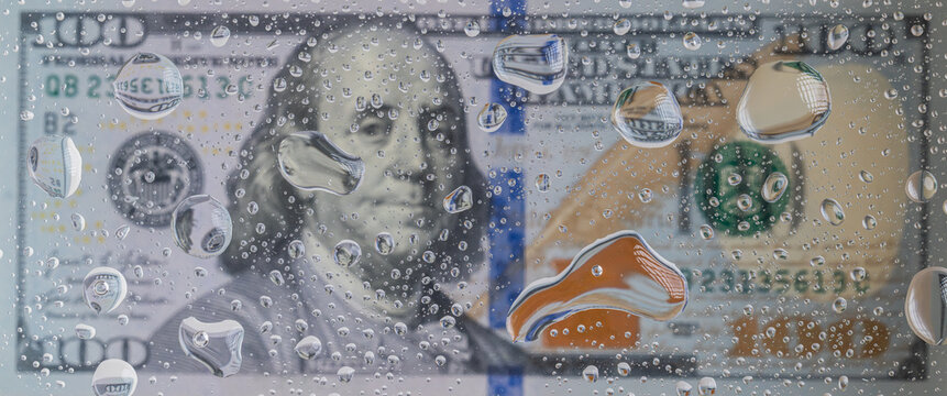 US one hundred dollar banknote seen through glass covered with water drops