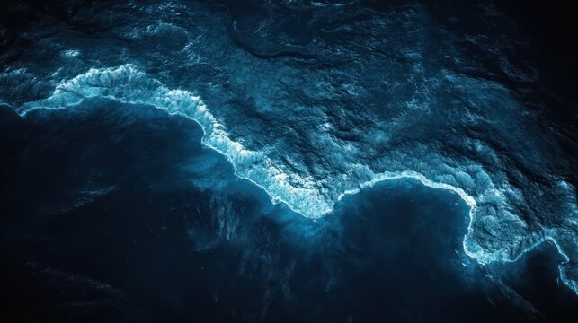 aerial view of dark ocean shoreline with foamy waves and dramatic moody seascape
