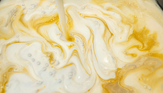 Creamy liquid swirls of white milk and golden honey blending together in a smooth abstract pattern with bubbles and fluid motion texture