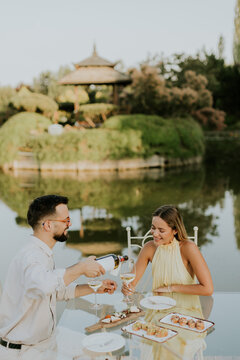 Celebrating a sweet moment by the serene lake with wine and laughter
