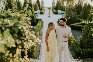 Couple enjoying a peaceful stroll through a beautiful garden at sunset © BGStock72