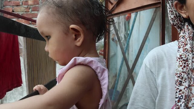 Video of an Indian mother gently showing her toddler's teeth while caring for her child. Authentic family footage capturing parenting, care, bonding, and everyday home life.