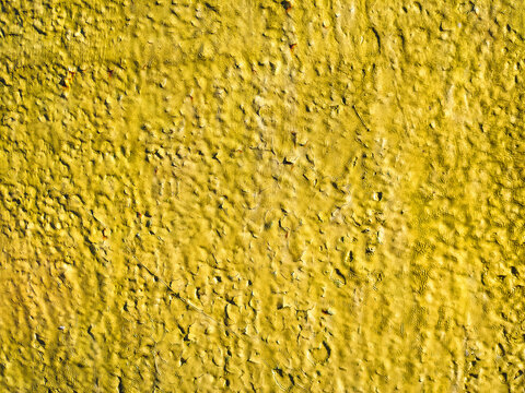 The background is made of metal and painted bright yellow. It has a grungy, lumpy, vintage texture with rust showing through.