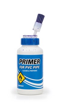Plastic bottle of purple pvc pipe primer with applicator brush for plumbing repairs