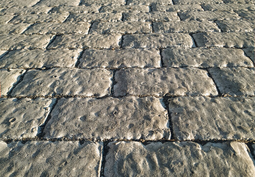 Light grey concrete covering with patterns reminiscent of ancient stonework with bricks. Covering the covering (floor) with cement decorative screed. Top view.