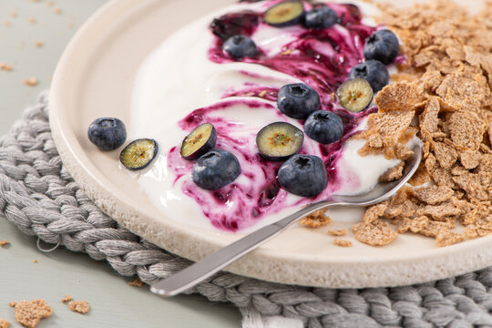 Healthy yogurt bowl with berry compote, blueberries, and crunchy cereal