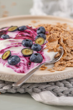 Healthy breakfast bowl with yogurt, berry compote, blueberries and cereal