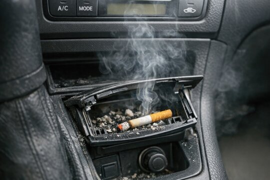 A woman sits in a classic car, holding a cigarette in a holder