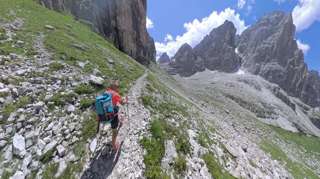 Hiker hiking toward Bocca di Brenta along the Via Ferrata Bocchette Centrali in the Brenta Dolomites