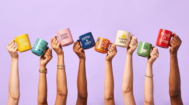 Diverse hands holding colorful coffee mugs.