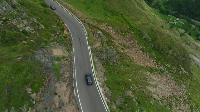 Aerial view of a car driving along the High Alpine Road in Austria. Steep uphill climbs along the winding road, beautiful mountain scenery in Tyrol, and travel across Europe.