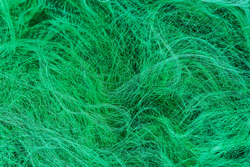 Fototapeta premium Close-up texture of a green nylon fishing net with tangled fibers and intricate woven patterns. 