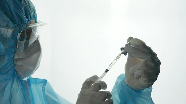Scientist Filling Syringe With Vaccine From Vial Bottle. Doctor Preparing Injection Dosage For Vaccination. Medical Laboratory 
