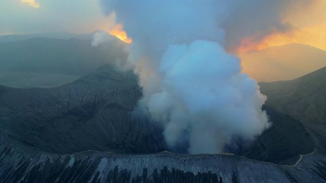 Breathtaking cinematic drone flight above Mount Bromo caldera &ndash; Spectacular volcanic steam rising over Java sand sea at sunrise, beautiful light rays, premium travel background asset 4k