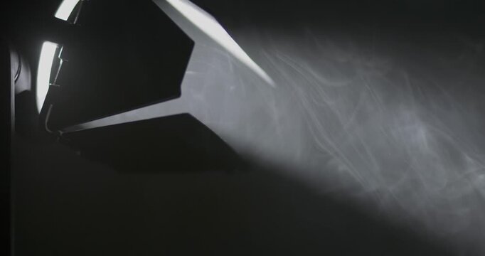 Light shines on smoke in studio setting during creative process