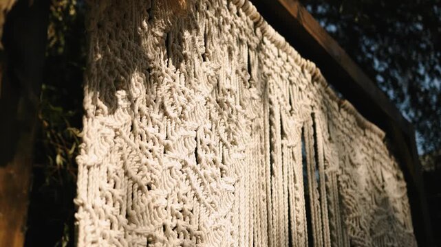 Macrame backdrop on wedding arch with handmade rope pattern. 4K slow motion.