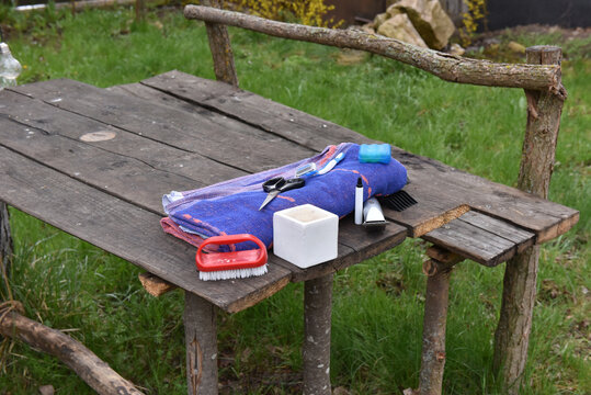 Grooming kit and hair cutting tools on a rustic outdoor wooden table