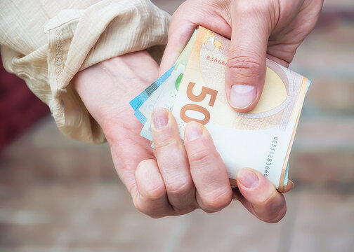 A man gives money to a woman, close-up.