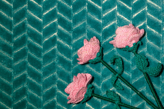 Handmade wool pink blossoms on soft green textile background
