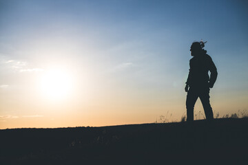 Fototapeta premium Confident Silhouette Standing Firm Against the Sunset Sky